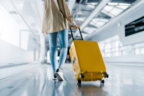 Woman carrying a suitcase through an airport