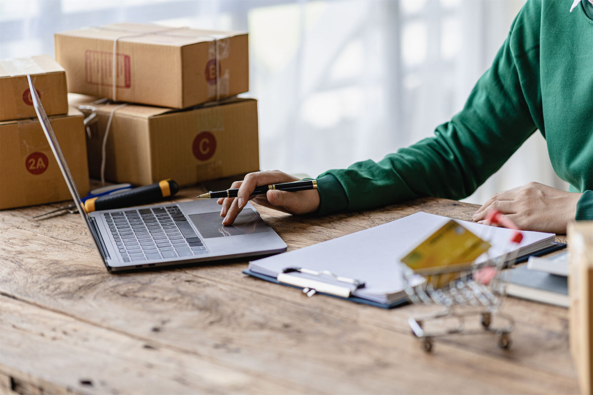 Person with boxes on their desk while working on their laptop